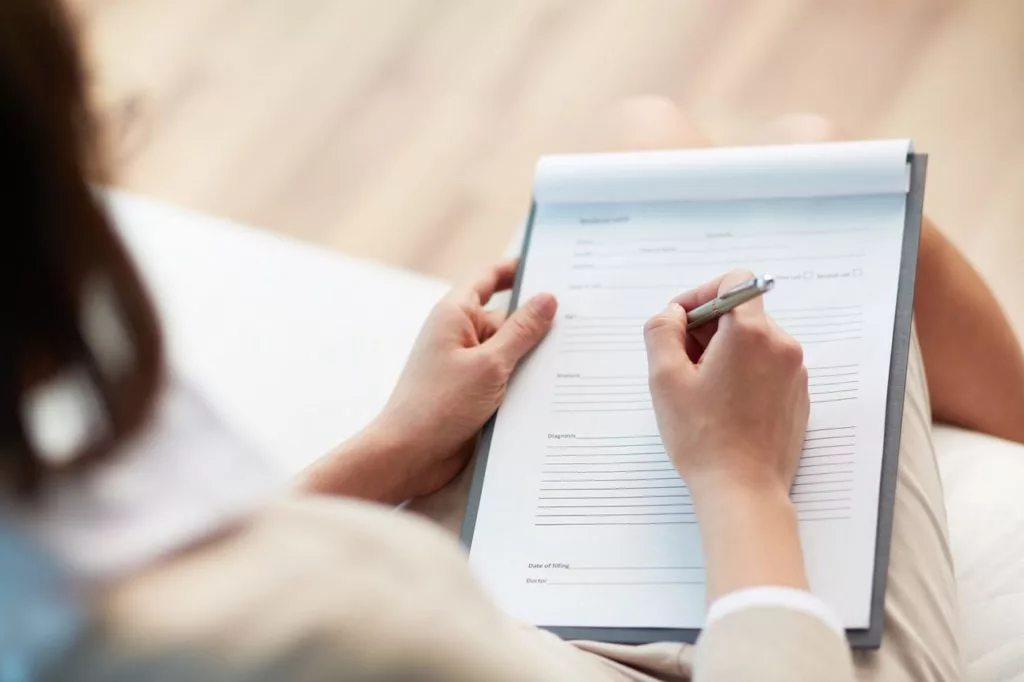 woman filling out dental insurance paperwork