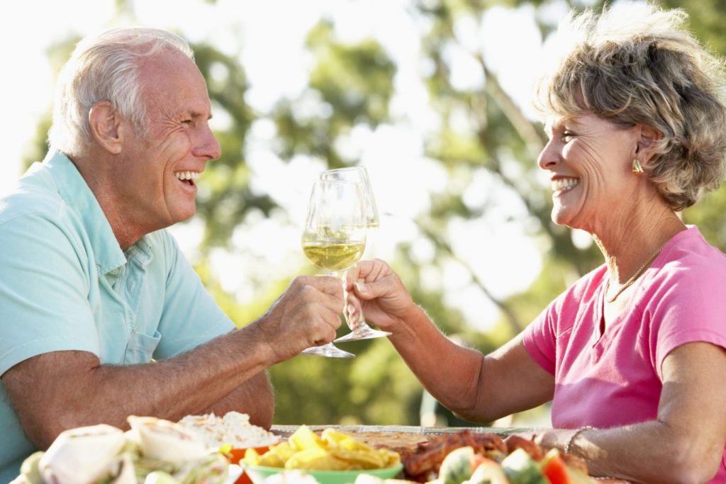 couple with dentures smiling together while eating dinner
