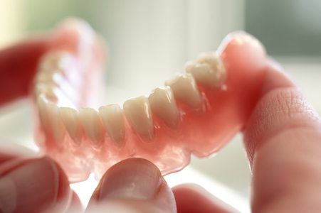 patient holding their dentures